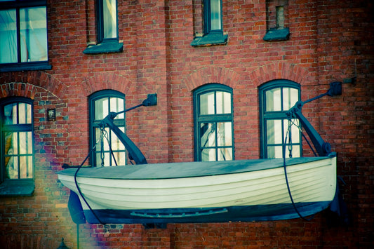 a white boat sitting in front of a red brick building