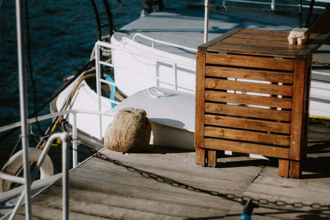 a cat sitting on a bench next to a boat