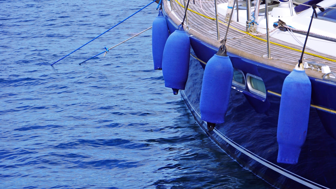 a boat with blue buoys tied to the side of it