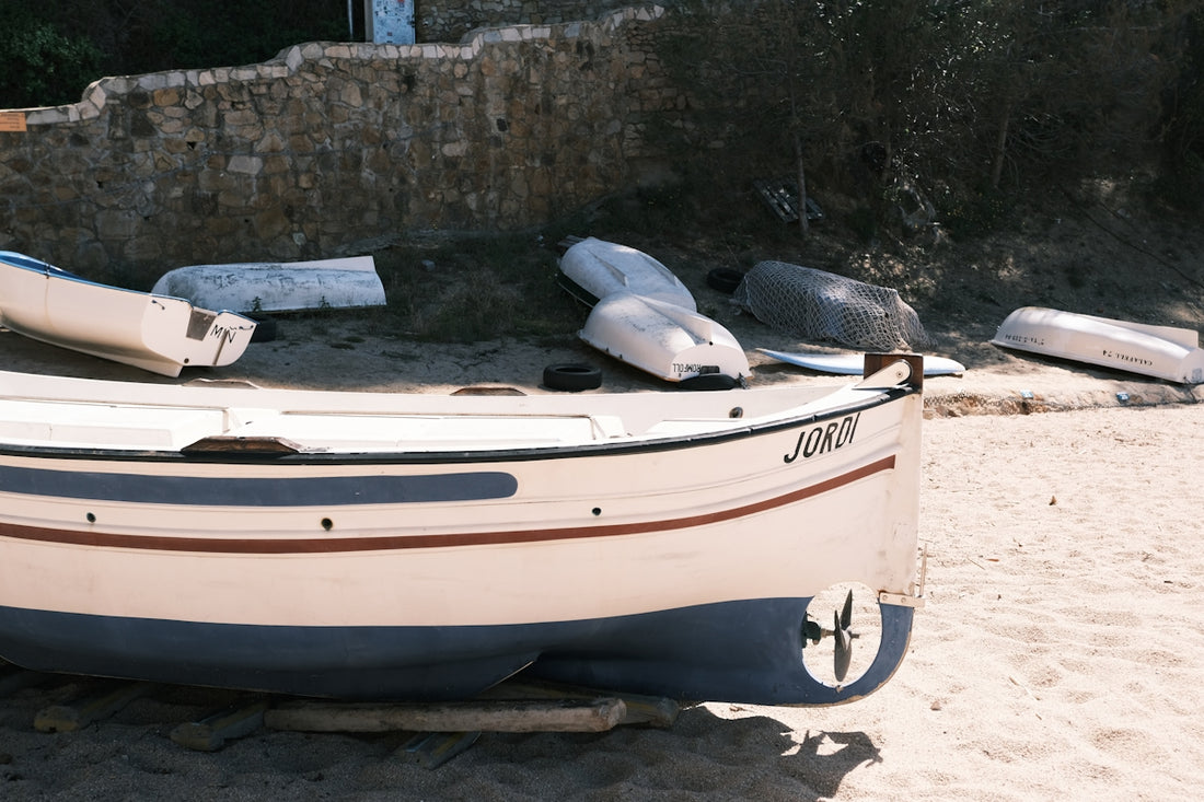 A small boat sitting on top of a sandy beach