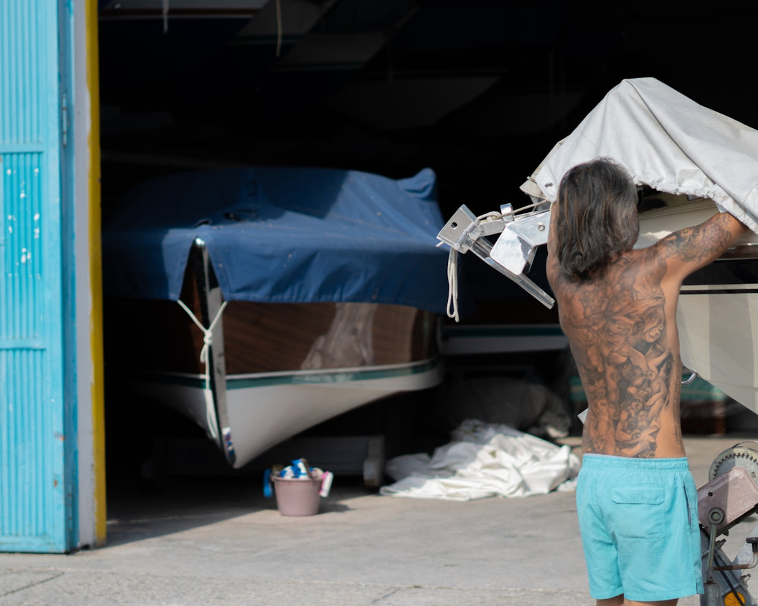 A man prepares boats for storage.